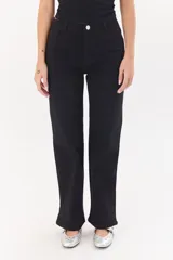 Pantalón color beige de corte recto, confeccionado en algodón y spandex. Presenta tiro medio y cierre frontal con botón y cremallera. Incluye cinturón marrón con hebilla plateada.