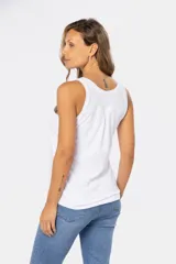 Musculosa blanca sin mangas, de corte clásico y calce cómodo, confeccionada en tejido suave. Presenta escote redondo, cartera con botones frontales y un pequeño bolsillo aplicado en el pecho.