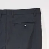 Pantalón de vestir de corte recto y estilo formal, confeccionado en tela de sastre color gris oscuro, con cierre de botón y cremallera, y bolsillos laterales.