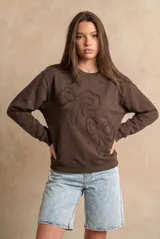 Sweater marrón de algodón con cuello redondo y diseño de moños en relieve bordados en el frente.