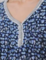 Conjunto de pijama de short y remera en tejido soft estampado. Remera de escote en V con aplique de puntilla, botones y detalle plisado. Short con cintura elastizada.