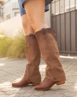 Bota alta de cuero y gamuza color marrón, con diseño 2 en 1 que incluye estribo desmontable, taco cuadrado y punta cuadrada.