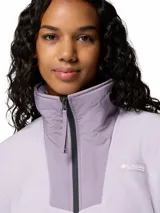 Campera polar Columbia modelo Sequoia Grove, color lila con detalles en tono más oscuro en la zona del cuello y cierre frontal. Presenta cuello alto, bolsillos laterales con cierre y ribetes elásticos en puños y dobladillo.