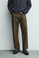 Pantalón de corte recto confeccionado en denim de algodón rígido con efecto lavado. Presenta tiro medio, cierre frontal con cremallera y botón, y diseño clásico de cinco bolsillos.