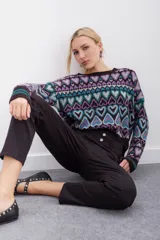 Pantalon negro de tiro alto con botones decorativos en la cintura, bolsillos delanteros aplicados y corte holgado.