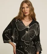 Blusa negra con estampado de hojas en color crema, escote en V y mangas 7/8.