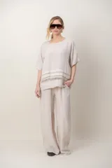 Pantalon de lino color azul, de corte ancho y relajado, con cintura elastizada ajustable mediante cordón y bolsillos laterales. Presenta detalles de alforzas en los bajos.