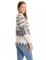 Buzo de tejido con textura ultrasuave, diseño de rayas horizontales y bloques geométricos en tonos blanco, gris y negro. Presenta cuello redondo, manga larga y un calce cómodo y holgado.