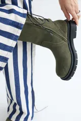 Botas de caña media color marrón, con cordones en la parte trasera y cierre lateral con cremallera.