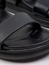 Sandalia baja con plataforma de 2 cm, presenta dos tiras anchas blancas sobre la capellada y base de color negro.