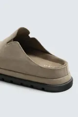 Zueco de piel con acabado serraje color beige, con plantilla anatómica, horma redonda y suela de volumen negra.