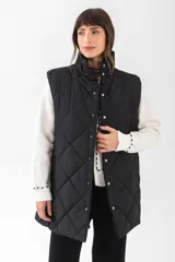Chaleco acolchado de corte recto y largo medio, con diseño de rombos, cuello alto y cierre frontal con botones a presión.