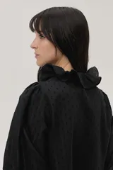 Blusa blanca con lunares en relieve, cuello con volados y lazos, mangas abullonadas 3/4 y bordados con lentejuelas en el frente.