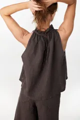 Blusa de lino italiano color marrón oscuro, con corte en línea A, hombros descubiertos, escote halter con frunces y volado en el cuello.