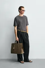 Bolso tipo bandolera de piel con acabado abatanado, diseño rectangular con doble asa de mano y detalle de llavero colgante. Cuenta con compartimento principal con cierre de mosquetón y bolsillo interior con cremallera.