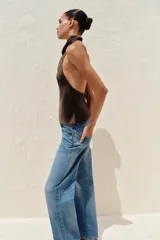 Top de cuello halter satinado en color naranja tostado, con espalda descubierta y cierre trasero de botones.