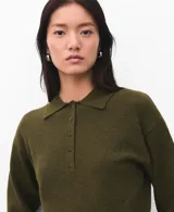 Chaleco de punto color verde oliva, con cuello polo y cierre frontal de botones. Presenta un diseño sin mangas y corte entallado.