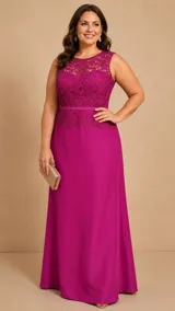 Vestido largo de fiesta color fucsia, con cuerpo de encaje sin mangas y falda de tafeta con corte asimétrico, más largo en la parte posterior. Presenta aplicaciones de pedrería al tono en el encaje y un fino cinturón integrado en la cintura.