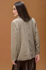 Blazer de corte clásico y silueta estructurada, confeccionado en tela con textura suave en tono beige. Presenta solapas tradicionales, cierre frontal con un botón oscuro y bolsillos laterales con solapa.