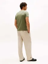 Remera verde militar de algodón elástico con cuello redondo y corte extra slim. Presenta logo de Tommy Hilfiger bordado en el pecho y cinta distintiva en el interior del cuello.