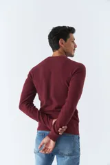 Sweater de punto color bordó, de corte clásico, cuello redondo y mangas largas. Presenta logo bordado en el pecho.