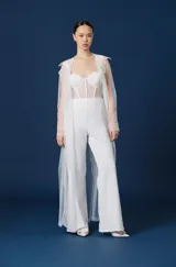 Trench largo de mujer confeccionado en tul transparente, con cuello camisero, mangas largas y frente abierto. Presenta una caída fluida y ligera, ideal para superponer sobre otras prendas.