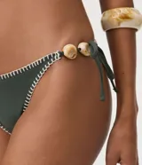 Bombacha de bikini verde militar de microfibra, con lazos laterales ajustables, pespuntes decorativos en contraste y aplique de cuentas de piedra.