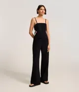 Mono largo negro de sarga de algodón, con escote recto, breteles finos, recorte en la cintura y lazo en la espalda.