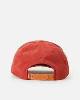 Gorro tipo gorra de pana color rojo ladrillo, con visera curva, cordón decorativo blanco en la base de la corona y parche bordado rectangular con diseño surf shop en tonos celestes y blancos.