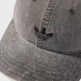 Gorra de béisbol con efecto lavado, confeccionada en sarga de algodón. Presenta un diseño clásico de seis paneles con ojales bordados para ventilación y un logo del Trifolio de Adidas bordado en el panel frontal. Incluye un cierre ajustable de anillos en forma de D en la parte posterior.