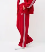 Pantalón deportivo de corte recto y holgado, color negro con rayas blancas laterales. Cuenta con cintura elástica con cordón ajustable, bolsillos laterales y detalle de costura vertical frontal.