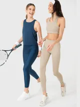 Musculosa deportiva de entrenamiento color azul denim, con cuello redondo y diseño sin mangas. Presenta paneles laterales con costuras reforzadas y tejido de malla en la espalda para mayor ventilación.