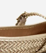 Bailarina de mujer con acabado metalizado y textura trenzada. Presenta una tira ajustable con hebilla metálica en el empeine y puntera redondeada.