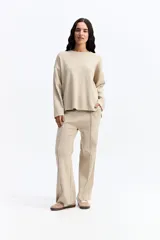 Pantalón de punto de tiro medio con corte recto y fit relajado. Presenta costuras verticales frontales que estilizan la silueta y bolsillos laterales.