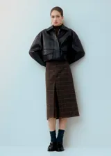 Falda midi de corte recto con diseño a cuadros en tonos marrones y negros, con una abertura frontal central.