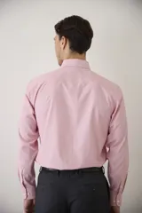 Camisa de vestir blanca de manga larga, con cuello clásico y cierre frontal de botones. Presenta un corte entallado que se adapta a la silueta.