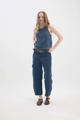 Top de jean blanco sin mangas, con escote redondo, espalda deportiva, costuras pespunteadas en el frente y ruedo desmechado.