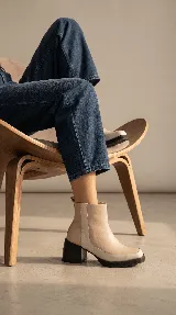 Bota corta de cuero negro con acabado brillante, diseño minimalista, taco cuadrado medio y plataforma delantera. Cuenta con cierre lateral interno para facilitar el calce.