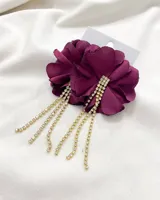 Aros colgantes con forma de flor color borgoña y flecos de strass dorados.