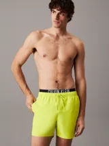 Bañador corto de hombre color amarillo flúor, con cintura elástica negra con logo Calvin Klein en blanco.