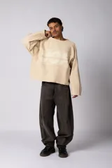 Buzo oversize de corte boxy, confeccionado en algodón rústico de alto gramaje en color beige. Presenta cuello redondo con borde crudo, mangas largas y una estampa frontal con el texto VCP delimitado por líneas horizontales blancas.