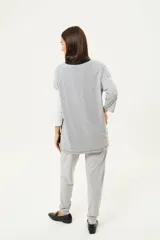 Remerón de manga tres cuartos con diseño de bloques de color en diagonal: gris claro en la parte superior izquierda, negro en la parte inferior derecha y blanco en la manga derecha. Posee cuello redondo y calce holgado.