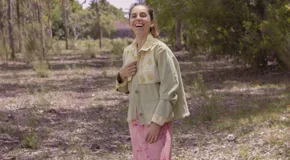 Chaqueta color beige con estampado abstracto en tonos amarillos, con cuello camisero, cierre frontal con botones, bolsillos plaqué y puños camiseros.