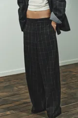 Pantalón de tiro alto con diseño de cuadros, pernera recta y cintura con trabillas. Cuenta con bolsillos laterales, bolsillos de vivo en la parte posterior y cierre frontal con cremallera, botón oculto y gancho metálico.