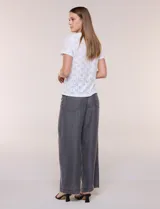 Remera blanca de calce recto con diseño de bordado calado estilo broderie, cuello redondo clásico y mangas cortas.