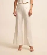 Pantalón wide leg de vestir color blanco, de tiro alto, con bolsillos delanteros con botón y pinzas delanteras.