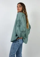 Blusa blanca de algodón con cuello mao y mangas 3/4 con detalles de encaje calado.