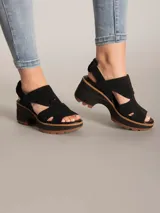 Sandalia de plataforma con capellada de gamuza negra, diseño de tiras anchas con aberturas laterales y cierre de talón. Cuenta con una suela de goma dentada en color marrón y entresuela de EVA.