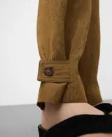 Pantalón de visco-poliamida color verde, efecto arrugado, con bolsillos frontales, costuras cargadas, cintura elástica en la espalda y bajo ajustable con trabilla y botón.