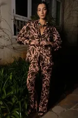 Blazer de corte holgado con estampado botánico en tonos marrón y rosado. Presenta cuello solapa, cierre frontal con botones, hombros sutilmente marcados y mangas largas con puños anchos.